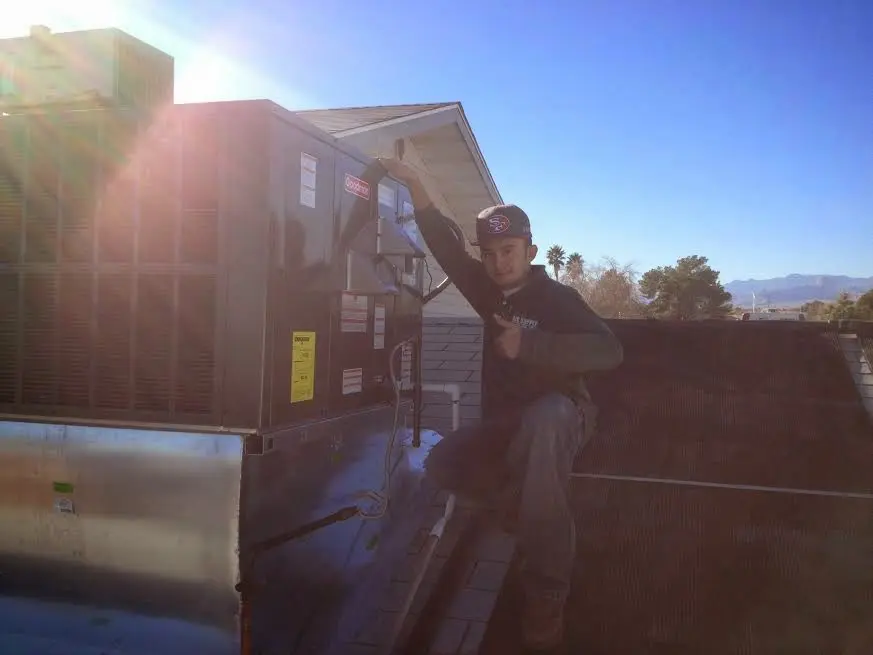 HVAC technician performing HVAC Inspection on a rooftop unit in Ellsworth